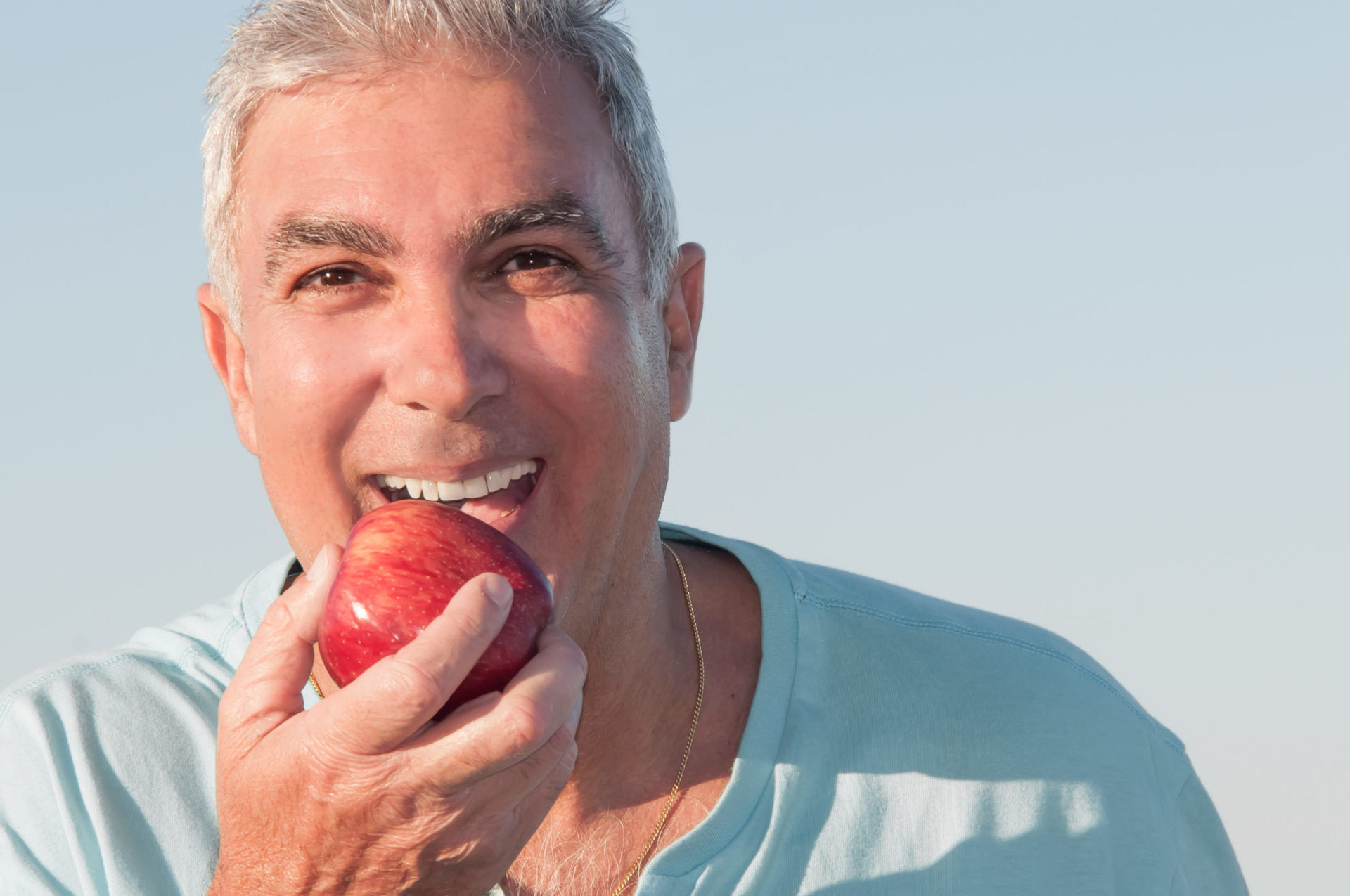 smiling man biting apple